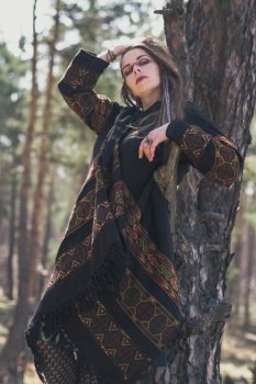 Languid woman in ethnic clothes scenic photography. Picture of person with spring forest on background. High quality wallpaper. Photo concept for ads, travel blog, magazine, article. Languid woman in ethnic clothes scenic photography