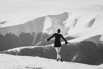 Female model in dress on mountain monochrome scenic photography. Picture of person with snow capped peaks on background. High quality wallpaper. Photo concept for ads, travel blog, magazine, article. Female model in dress on mountain monochrome scenic photography