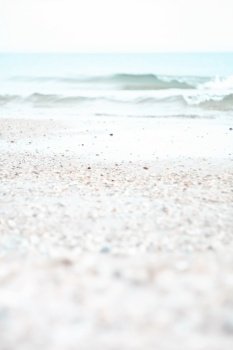 Close up white sand beach and ocean waves concept photo. Tropical resort. Front view photography with blurred background. High quality picture for wallpaper, travel blog, magazine, article. Close up white sand beach and ocean waves concept photo