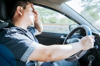 fatigued driver stuck in traffic, concept of a fatigued man in his car, stressed. A driver with a headache in traffic, A person with a headache in traffic