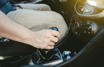 Close up of hand accelerating on gear stick. Close-up of driver hand on the gear lever of a car, Driver hand grabbing car gear stick