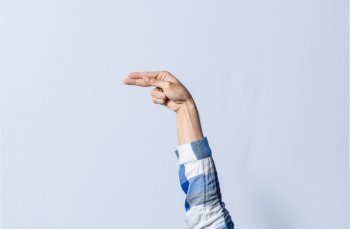 Hand gesturing the letter H in sign language on an isolated background. Man’s hand gesturing the letter H of the alphabet isolated. Letters of the alphabet in sign language