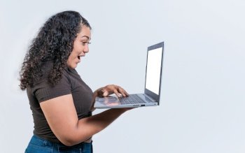 Surprised girl looking at an promotion on laptop screen isolated. Amazed latin woman using laptop isolated. Latin people looking offer promo on laptop isolated.