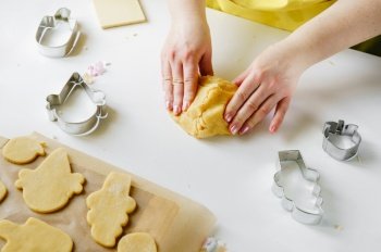 Female hands knead the pastry dough for sugar cookies in ice cream cone shape. Summer concept. Female hands knead the pastry dough