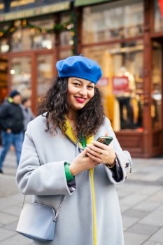 Portrait of happy mature woman looking at camera. Woman holding smartphone. Everyday technology, Christmas holidays. Portrait of happy mature woman looking at camera