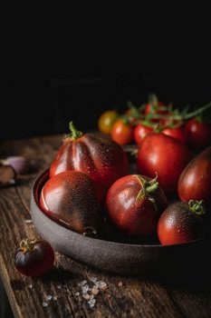 Composition of variety mix colorful tomatoes. Fresh tomatoes on Rustic stile dark background.. Mix colorful tomatoes