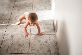 Blue-eyed baby crawling on the floor at home