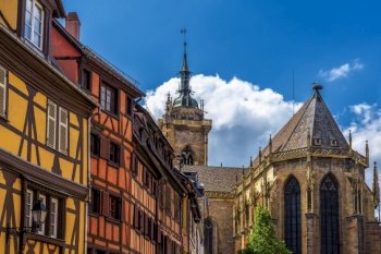 Colmar, France - 29 May, 2022: Church of St. Martin and colorful half-timbered houses in the historic center of Colmar