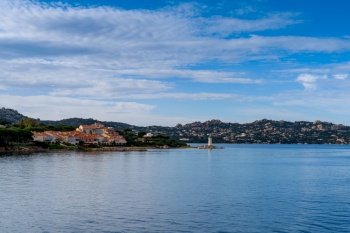 Palau, Italy - 3 December, 2022: shoreline with lighthouse and picturesque village in northern Sardinia