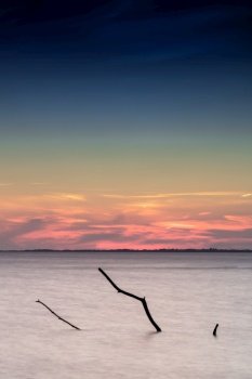 A beautiful sunset on the coast of Rugen Island in Germany long exposure with a driftwood