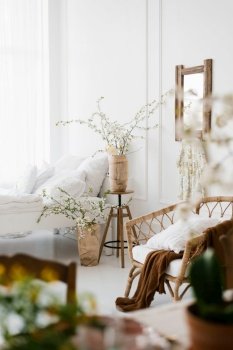 The interior of a beautiful white modern bedroom with spring flowers