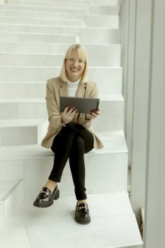Businesswoman working on digital tablet on the modern office stairs