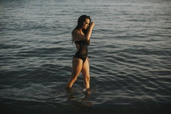 Pretty young woman walking in water at the beach