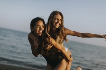 Two pretty young women having fun at summer vacations on the beach