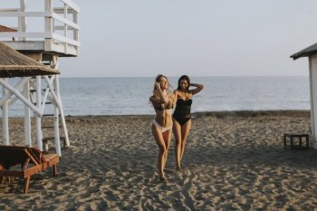Two pretty young women having fun at summer vacations on the beach