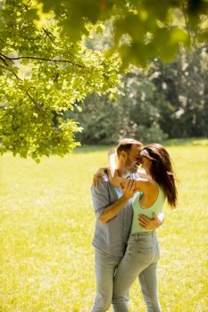 Happy young couple in love at the grass field on a summer day