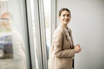 Pretty young woman standing in modern office