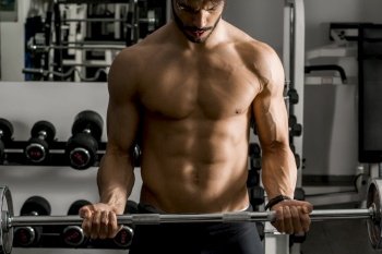 Portrait of strong and handsome young man doing exercise with dumbbells