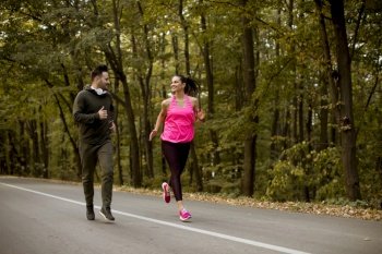 Young people jogging and exercising in autumn nature enviroment