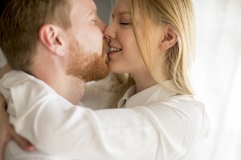 Happy and loving young couple kissing in the room