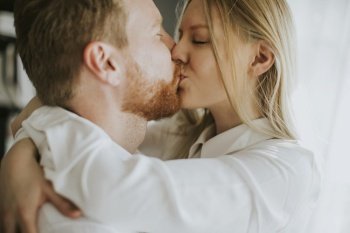 Happy and loving couple kissing in the room