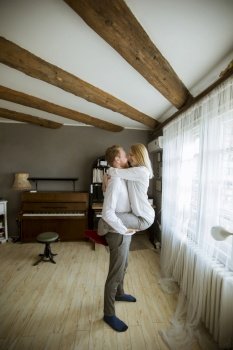 Happy and loving young couple kissing in the room