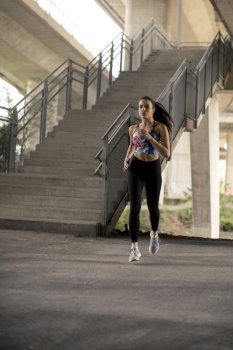 Young woman exercise in urban environment by day