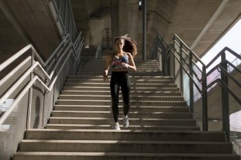 Young woman running alone down stairs  outdoor in urban environment