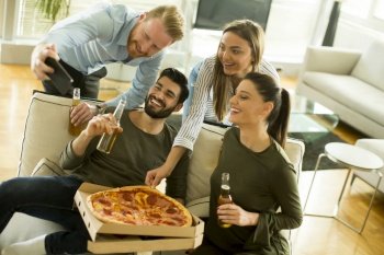 Group of young people taking selfie on the  pizza party in the room