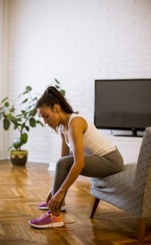 Cute young attractive woman preparing for exercises at home