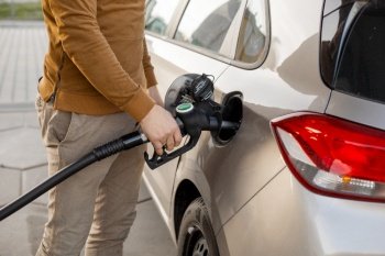 Car refueling on the petrol station. Man refilling the car with fuel. Close up view. Gasoline, diesel is getting more expensive. Car refueling on the petrol station. Man refilling the car with fuel. Close up view. Gasoline, diesel is getting more expensive.