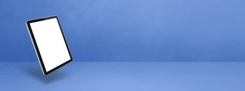 Blank tablet pc computer floating over a blue background. 3D isolated illustration. Horizontal banner template. Floating tablet pc computer isolated on blue. Horizontal banner background