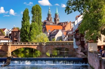 Sunny church and bridge over Pegnitz River in the Old Town of Nurnberg, eastern Bavaria, Germany. Nuremberg, Bavaria, Germany