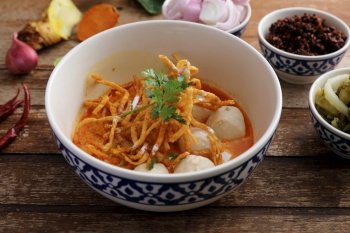 Local northern Thai food Egg noodle curry with meatballs on wood background