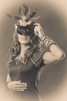 Holidays, people and celebration concept. Woman with carnival venetian mask, vintage photo sepia tone