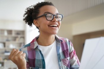 Excited african american teen girl in glasses feels happiness, received good news. Biracial female student celebrate victory, enjoy success, personal achievement, got student scholarship.. Excited african american teen girl in glasses celebrate victory, enjoy success, personal achievement