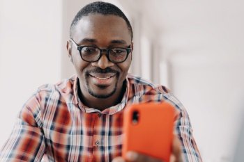 Face of happy african american man. Freelancer has video call on phone. Working remotely from home on quarantine. Consulting or corporate discussion. Distance briefing. Workplace while the pandemic.. Face of happy african american man. Freelancer is working remotely from home on quarantine.