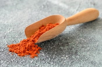 Red paprika in wooden scoop close-up