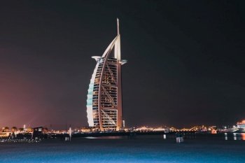 DUBAI, UAE - FEBRUARY 2018 :The world’s first seven stars luxury hotel Burj Al Arab at night seen from Jumeirah public beach in Dubai, United Arab Emirates