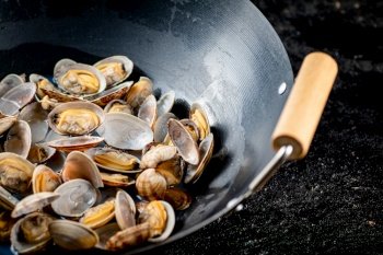 Vongole in a pot of water. On a black background. High quality photo. Vongole in a pot of water. 