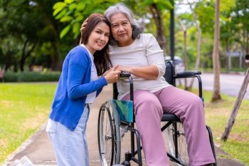 Asian careful caregiver or nurse taking care of the patient in a wheelchair.  Concept of happy retirement with care from a caregiver and Savings and senior health insurance, a Happy family