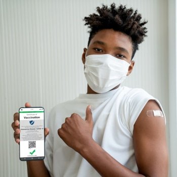 African American teenager shows vaccine passport on mobile phone to validate travel permission by the digital document. African American teenager shows vaccine passport on mobile phone