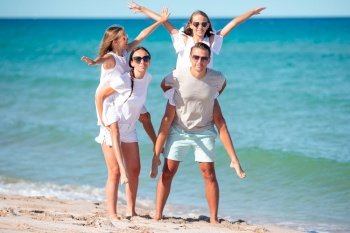 Happy family on the beach during summer vacation. Young family on vacation have a lot of fun