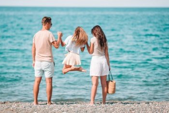 Happy beautiful family with kid together on tropical beach during summer vacation. Young family on vacation have a lot of fun
