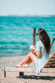 Beautiful woman on the beach vacation. Young woman with cup of hot coffee enjoy holidays