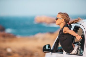 Happy girl on vacation by car at summer day. Family on vacation. Summer holiday and car travel concept