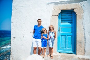 Family vacation in Europe. Father and kids background Mykonos town in Greece. Family having fun outdoors on Mykonos island