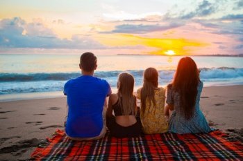 Happy beautiful family at sunset on the beach. Young family on vacation at the evening