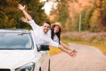Summer car trip and two young people. Happy family look from car and have fun. Young couple tourist enjoying on summer vacation
