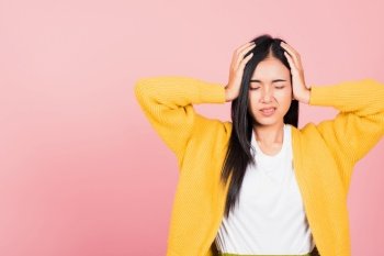 Portrait of beautiful Asian young woman sad tired strain face holding hold head by hands, female person closed eyes problem she headache, studio shot isolated on pink background